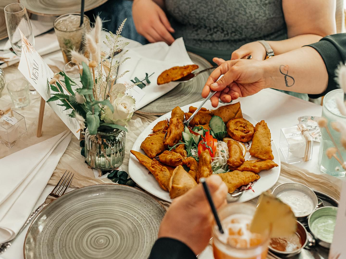 Hochzeitsgäste teilen sich indische Vorspeisen mit Samosas und Pakoras