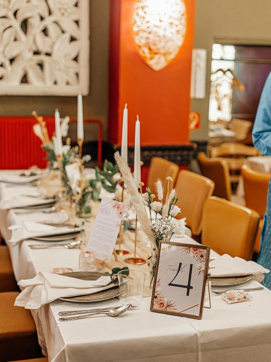 Eingedeckte Hochzeitstafel mit Kerzen, Trockenblumen und Tischnummer