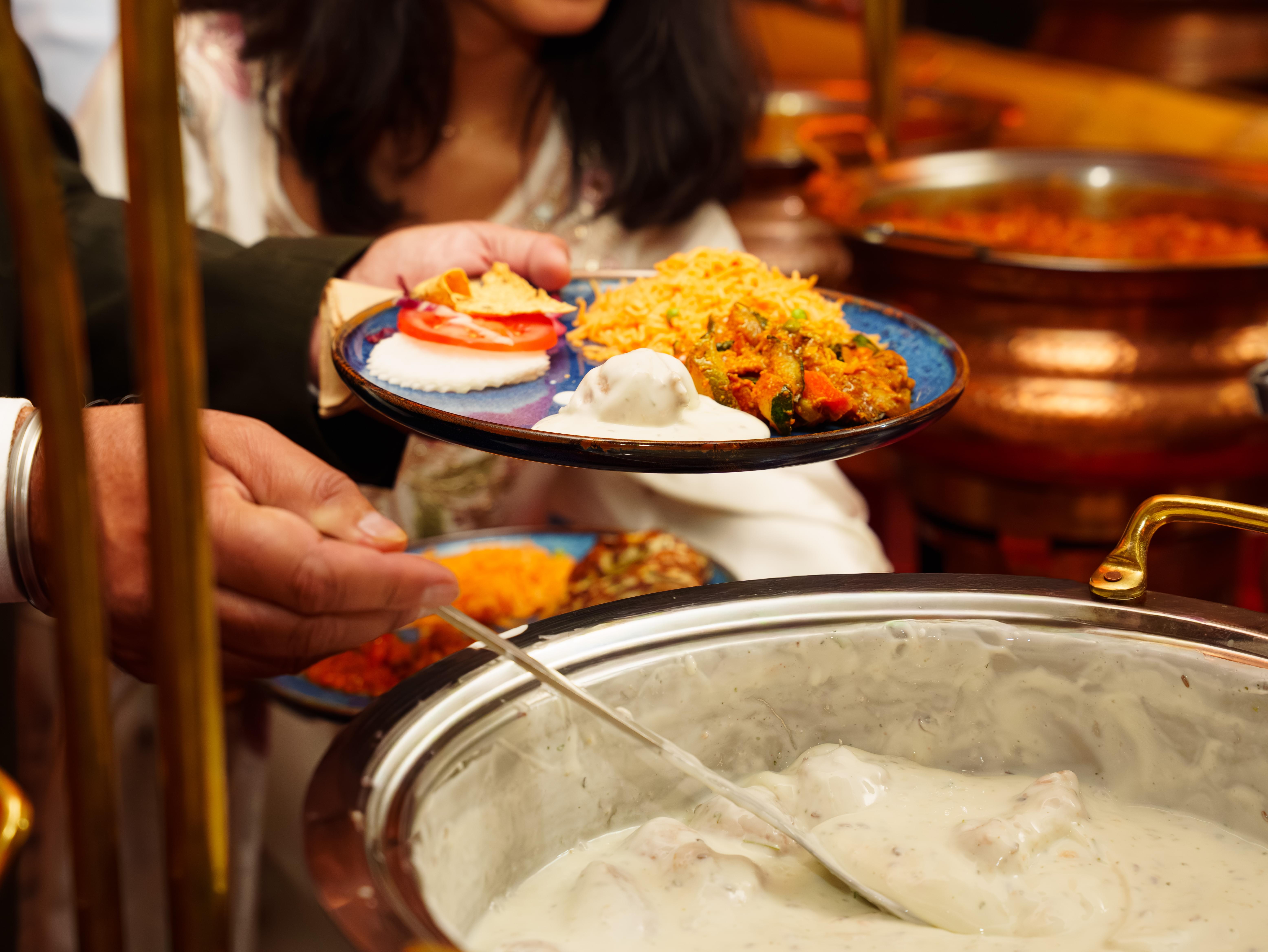 Gast am indischen Buffet mit Chafing Dishes bei einer privaten Feier