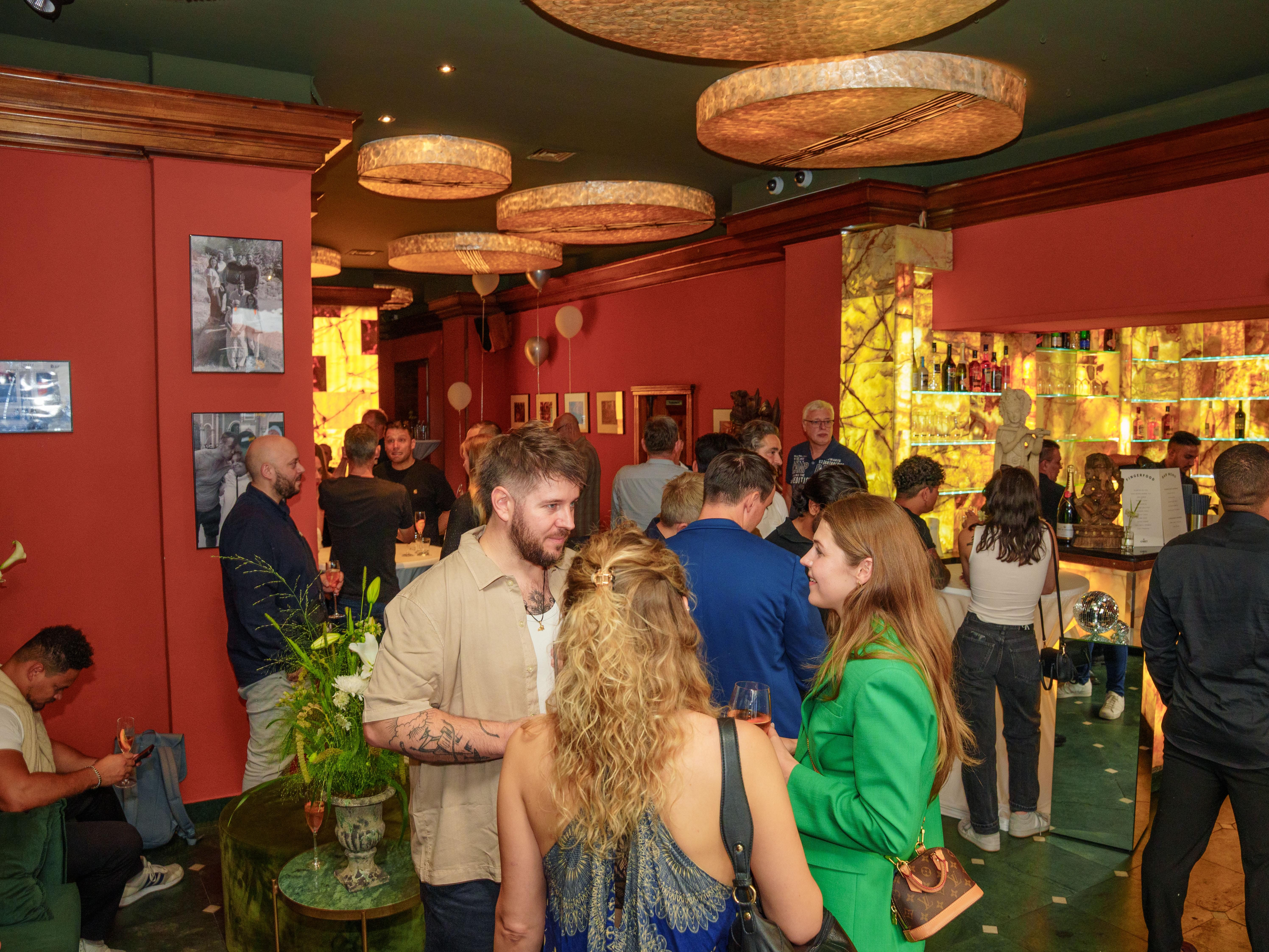 Gäste feiern in der Bar von THE ORIGIN by AMRIT in Berlin-Kreuzberg