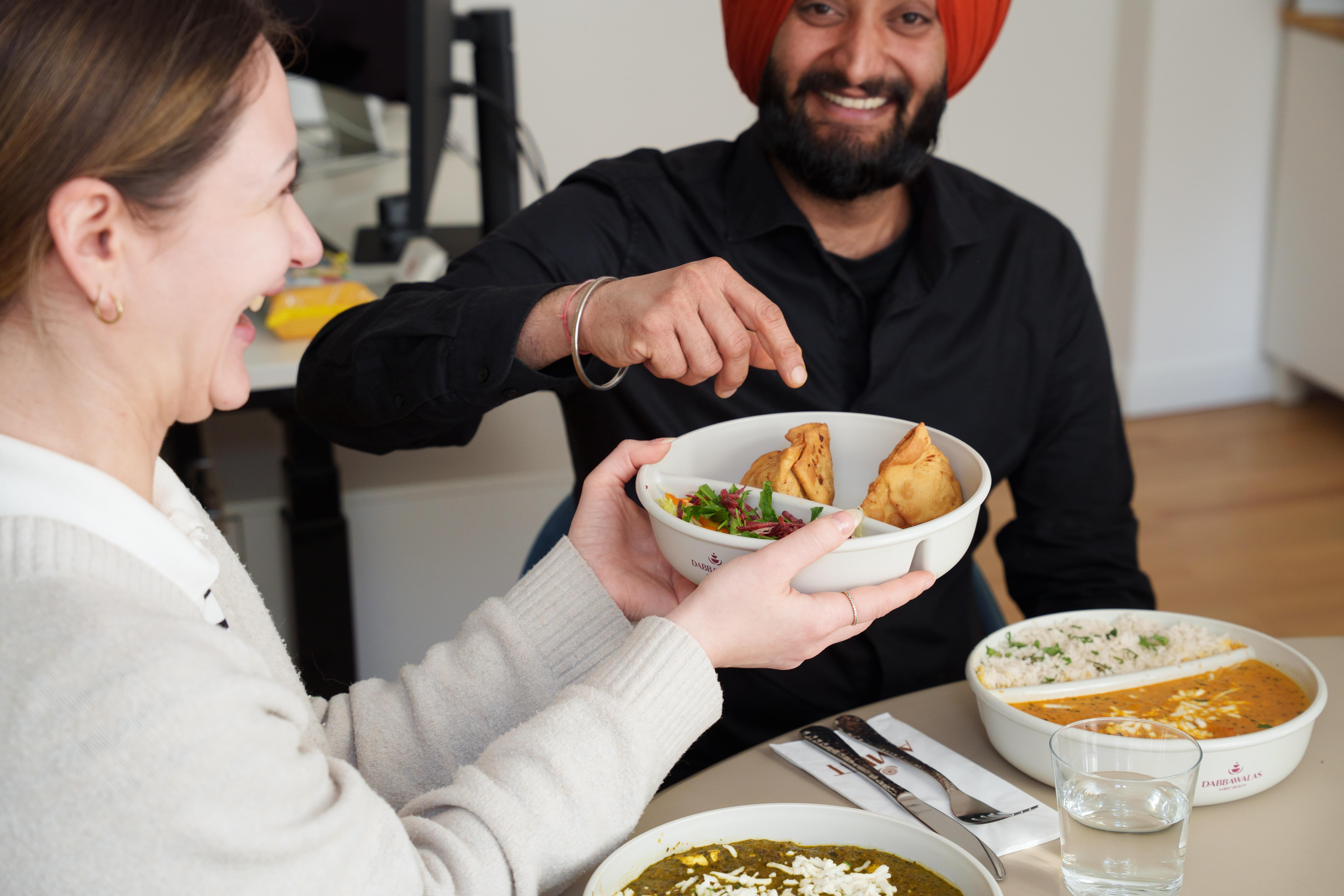 Team teilt sich Samosas und Currys aus der AMRIT Office Lieferung