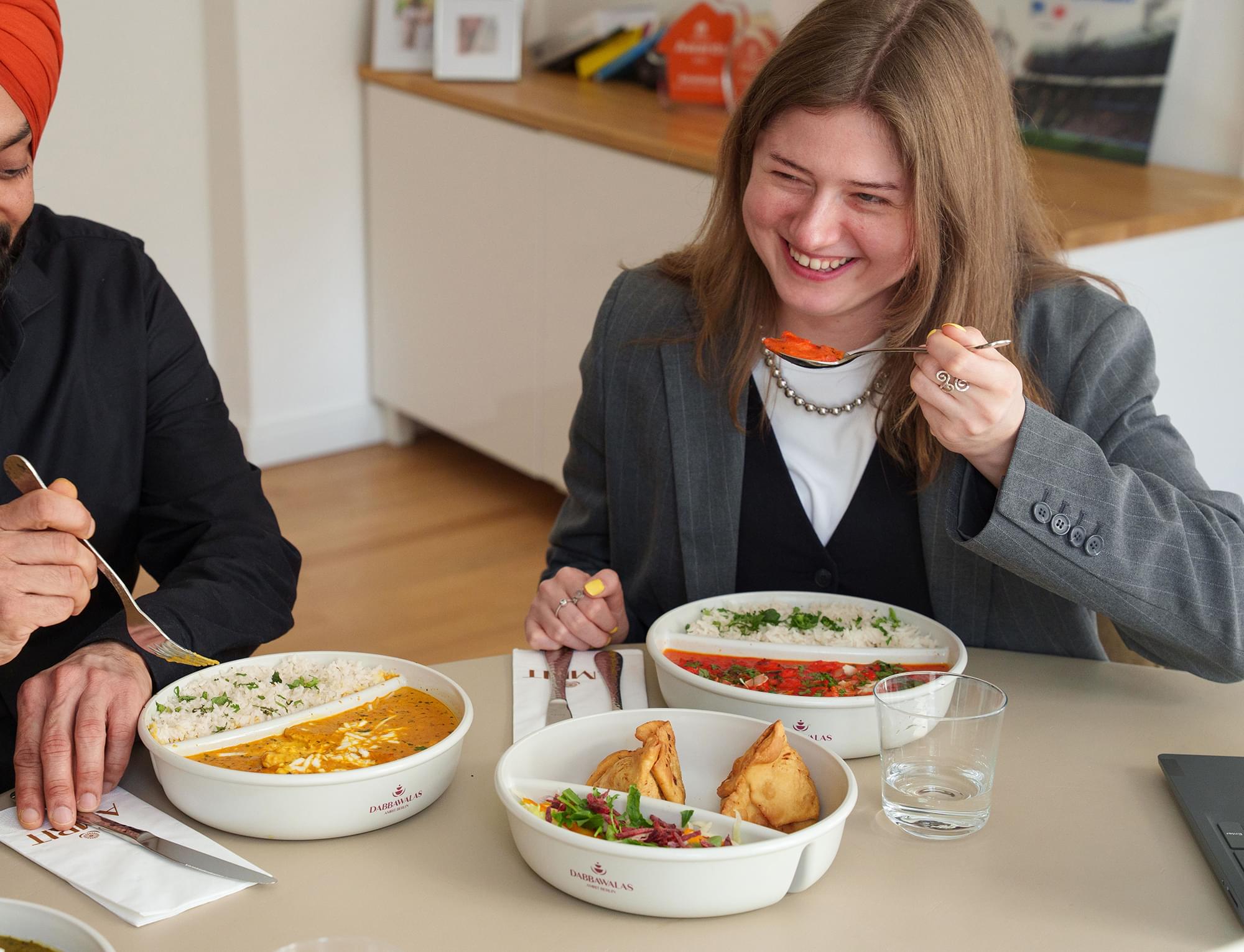 Crew-Mitglieder beim Lunch mit indischen Gerichten aus Mehrwegschalen
